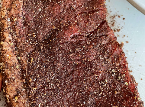 A photograph of a NY strip steak rubbed with Peets Major Dickasons coffee rub, before grilling